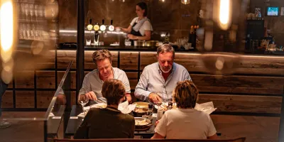 2 mannen en 2 vrouwen tafelen in een restaurant