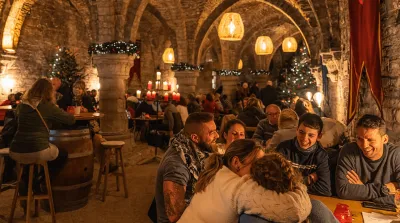 Mensen zitten samen aan tafeltjes en genieten van elkaars gezelschap