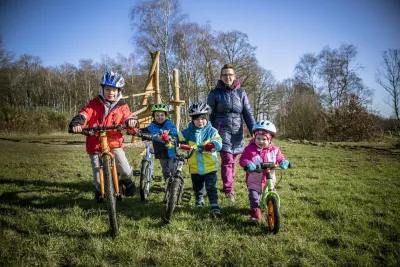 Mama en kindjes op de (loop)fiets poseren voor een foto