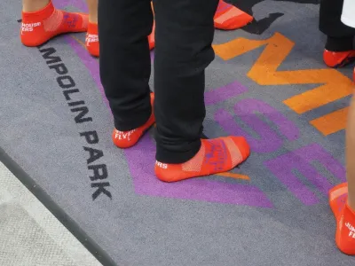 Mensen staan met trampolinekousen op een mat in een trampolinepark