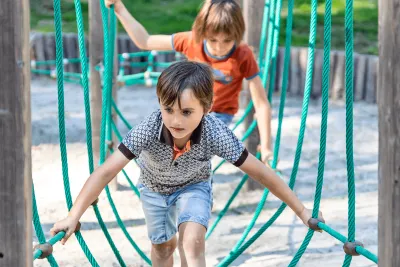 Twee kinderen spelen in een speeltuin