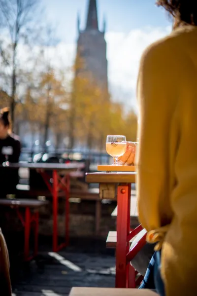 Bierroute Vlaanderen: vrouw drinkt bier op terras