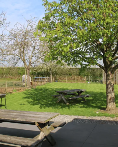 Tuinzicht bij Bocage Natur met een picknickbank en een boom