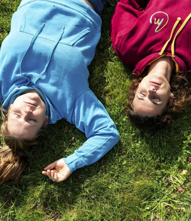 Twee vriendinnen liggen languit in het gras