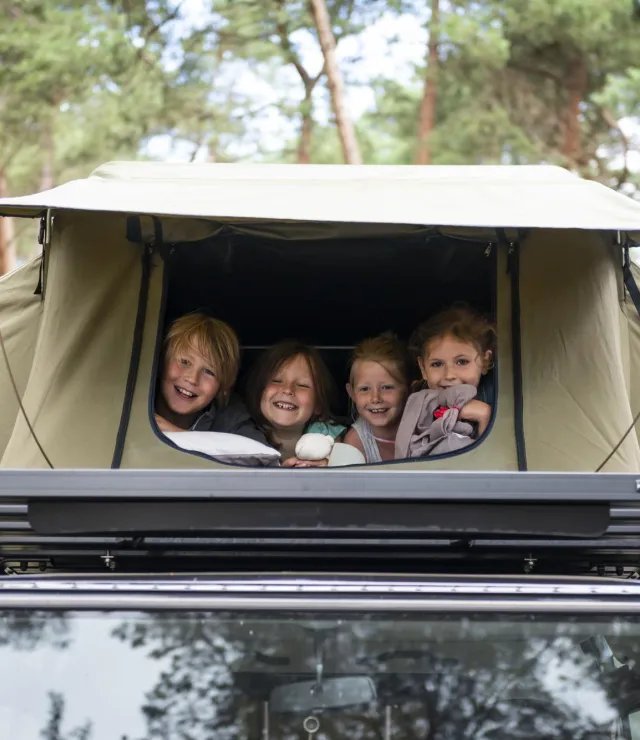 Kinderen in een daktent