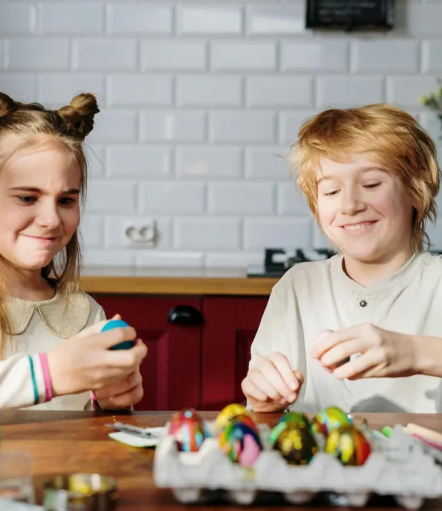 Twee kinderen die paaseieren aan het verven zijn