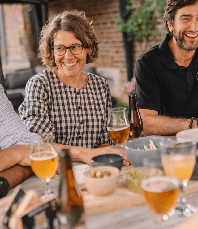Mannen en vrouwen lachen en genieten van bier