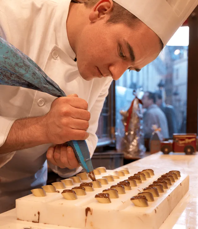 Chocolatier spuit chocolade in een vorm