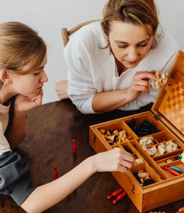 Moeder en dochter kijken samen naar een spelletjesdoos