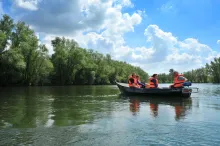 3 mensen in een bootje met reddingsvesten aan